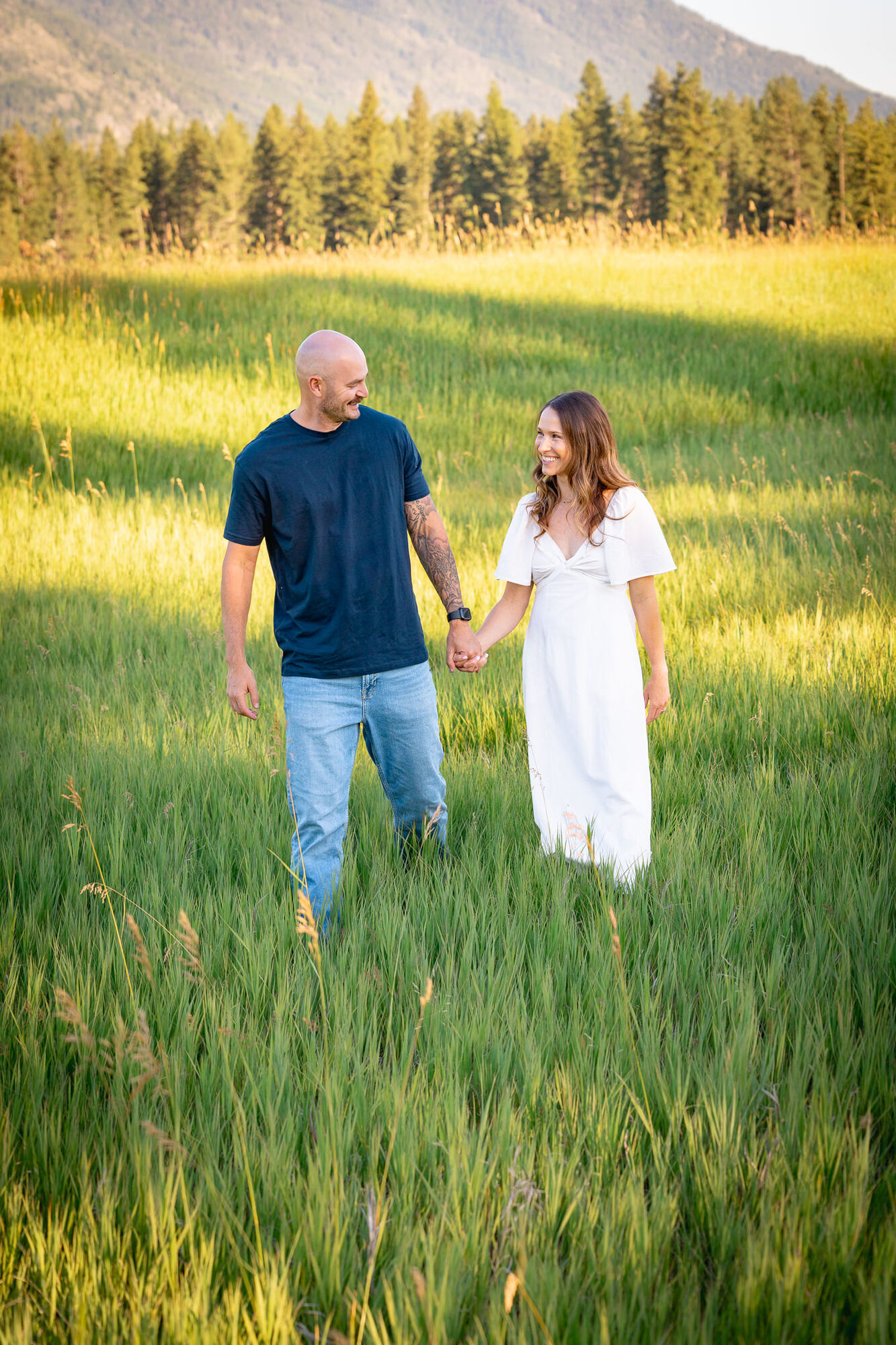Man kissing his partner's forehead in a golden, backlit field