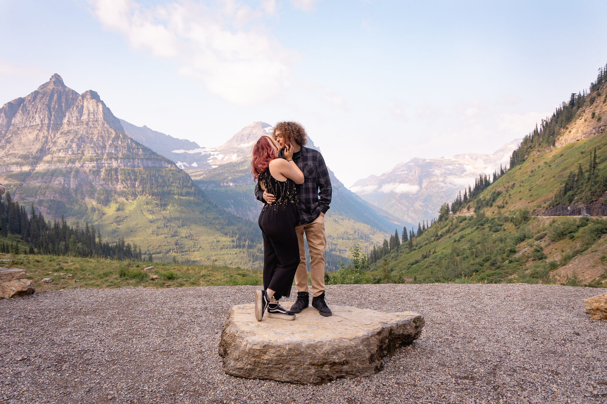 Couple kissing on a granite overlook above St. Mary Lake, Glacier National Park, at golden hour